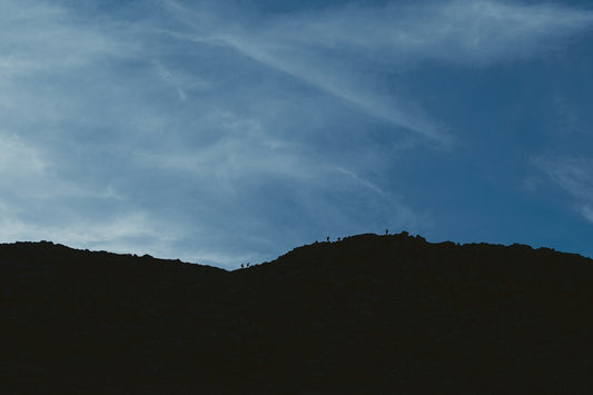 silhouette of mountain under cloudy sky during daytime