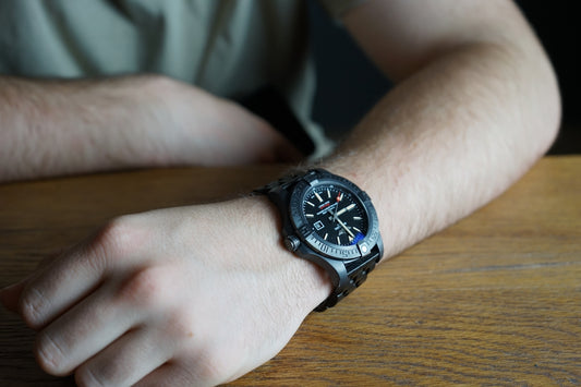 person wearing black and silver round analog watch