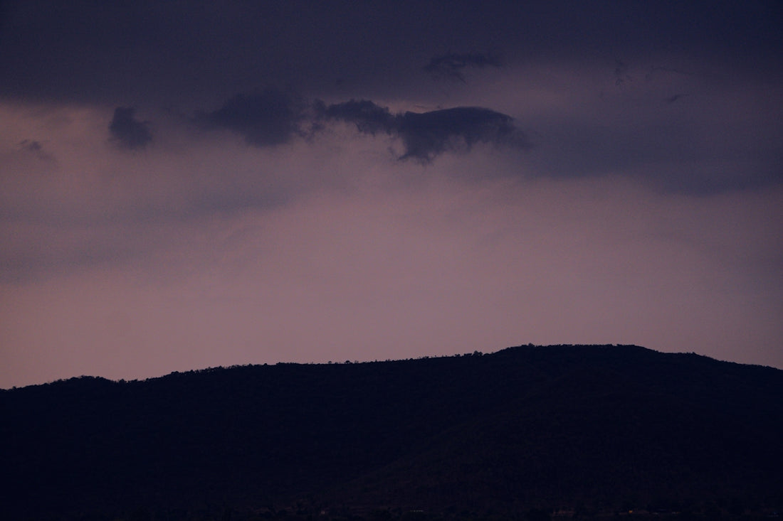 a hill with a dark sky in the background