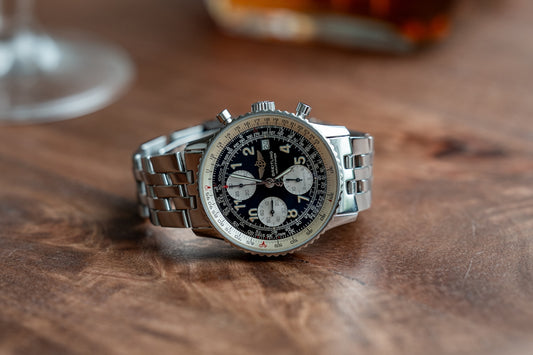 A luxurious breitling watch sits on a table.