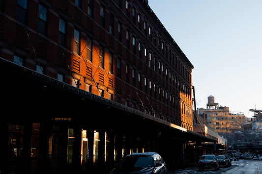 Brick building with sunlight reflecting on windows.